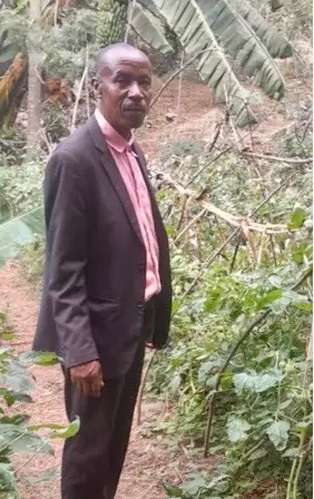 Jean stands on his farm in Rwanda.
