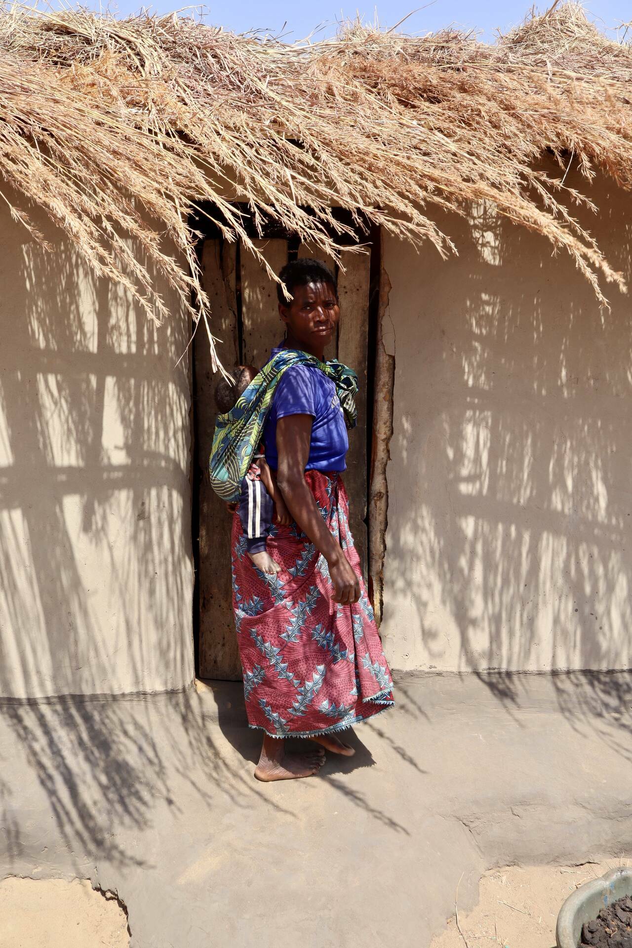 A smallholder farmer outside her home in Malawi.
