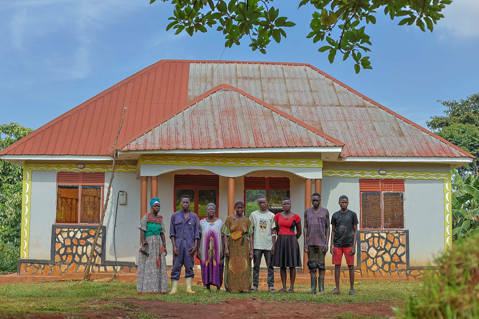Namulondo's family standing in front of their home.