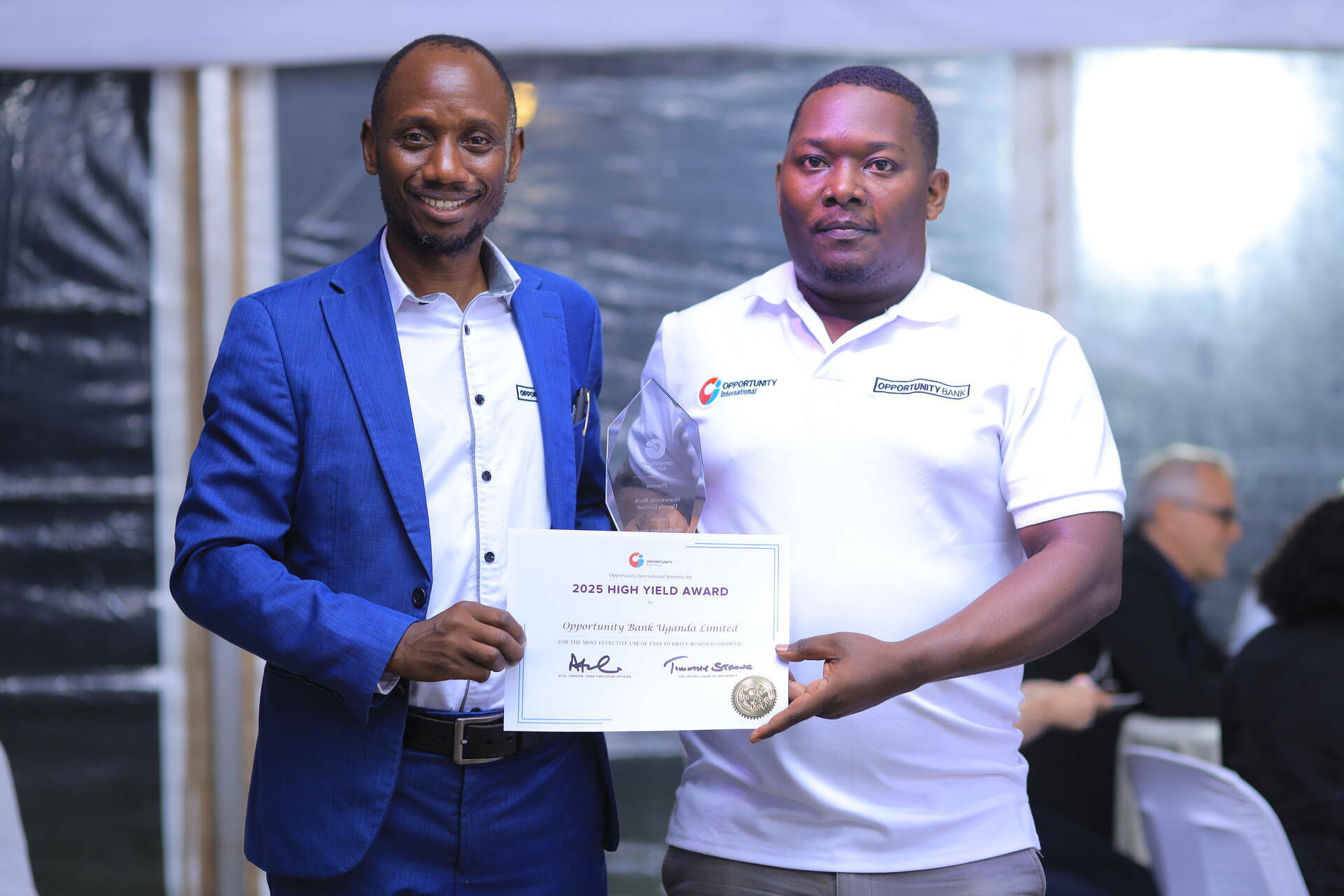OBUL team members Amos Bonna (left, Chief Relationship Officer) and Farooq SSekamatte (right, Agriculture and Microfinance Manager) accepting AgFinance's High Yield award at the 2025 Summit