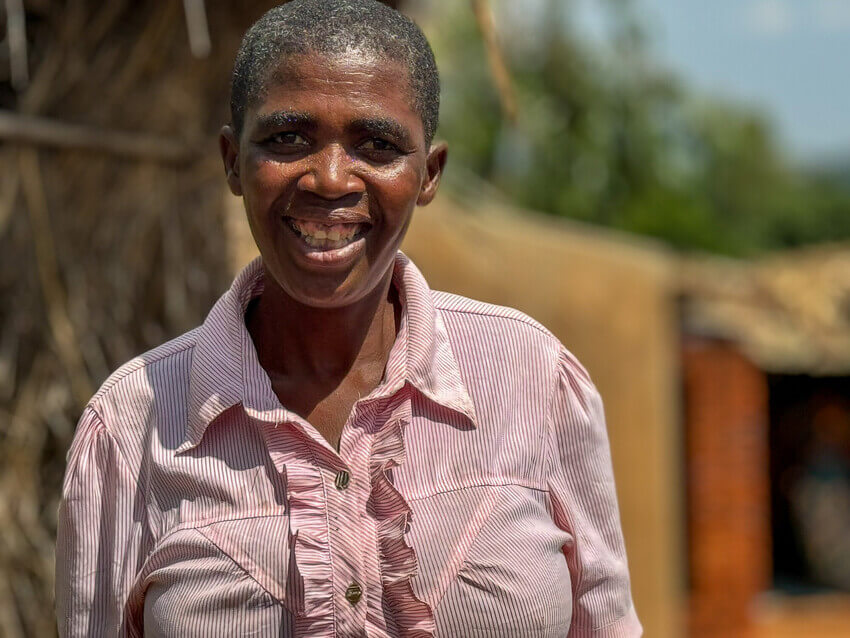 Rose, a member of the Malawi graduation program, poses outside her home in rural Blantyre, Malawi on April 24, 2024