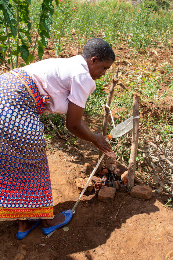 Rose, demonstrating how to use the hand-washing station she was taught to construct as a part of the graduation program. 